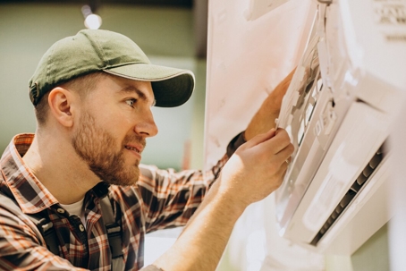 A guy fixing an AC unit