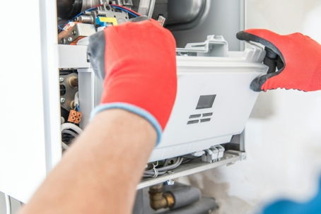 A technician repairing a furnace unit