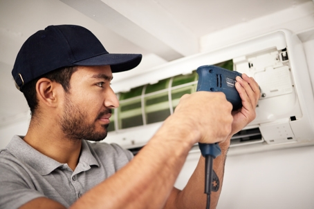 A technician fixing an AC unit