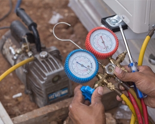 Close up of a technician holding an HVAC manifold gauge set