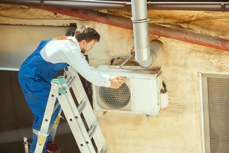 A guy fixing an AC unit