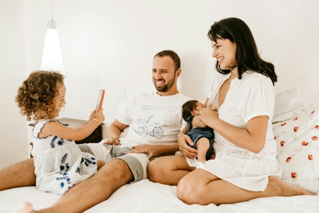 A picture of a family enjoying taking a photo of her sibling and mother