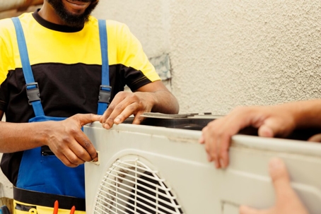 Two technicians repairing the AC unit